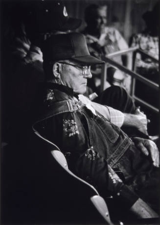 Title unknown (profile of seated man with ball cap and glasses)