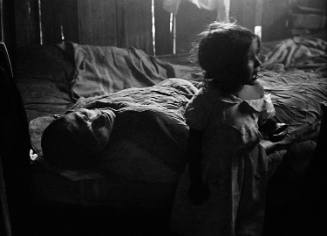 In the shadowy slum into which she was born in Rio de Janeiro, 3-year-old Isabel da Silva cries to herself after vainly seeking comfort from her exhausted father, José. 